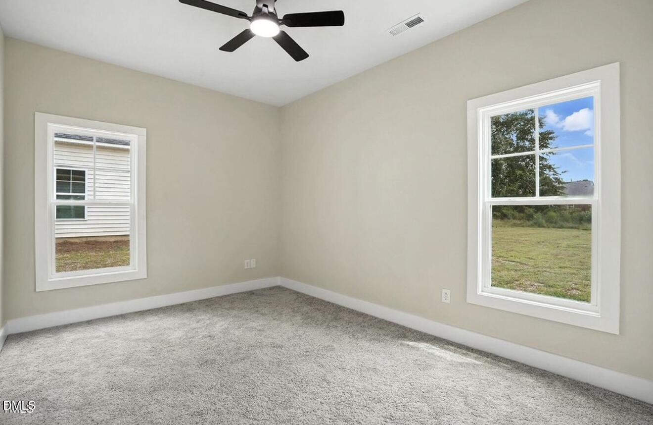 1240 West Blackman Road Dunn, NC 28334 - Photo 18 of 25 an empty room with a window and a ceiling fan