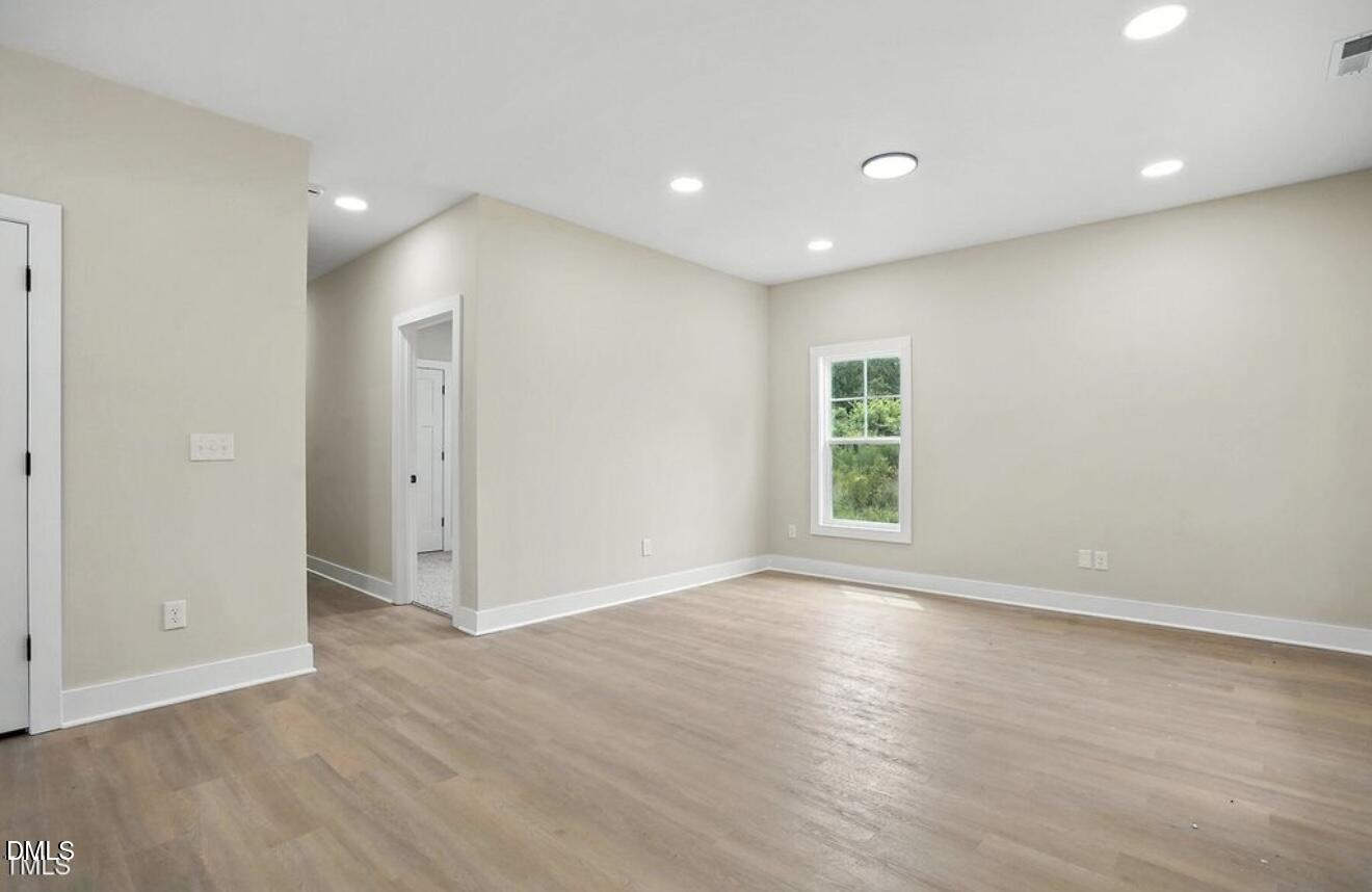 1240 West Blackman Road Dunn, NC 28334 - Photo 5 of 25 a view of empty room with wooden floor and fan