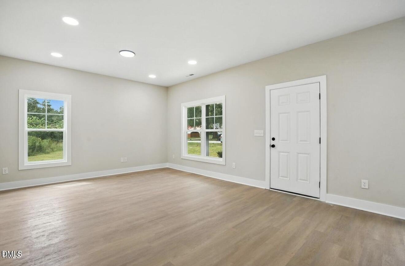 1240 West Blackman Road Dunn, NC 28334 - Photo 6 of 25 a view of an empty room with wooden floor and a window
