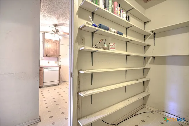 a view of walk in closet with empty racks