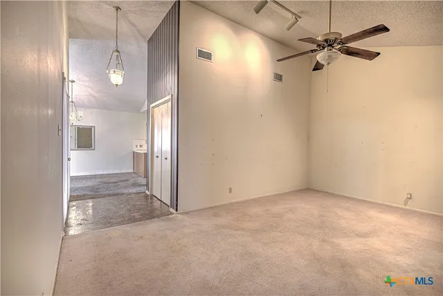 a view of a hallway with a chandelier fan and windows