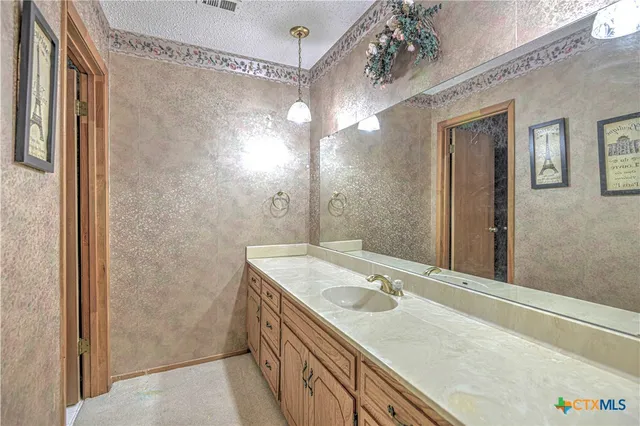 a bathroom with a sink vanity granite and shower