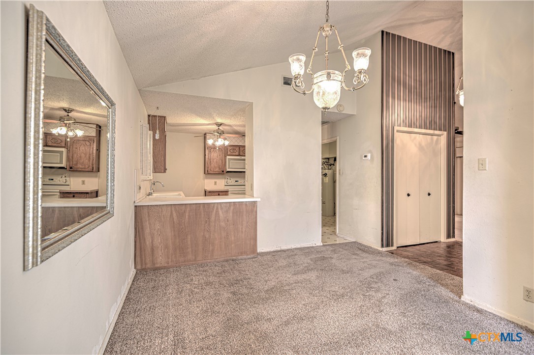 4000 Hickory Road, Unit 3 Temple, TX 76502 - Photo 8 of 34 a view of a hallway with wooden floor and chandelier