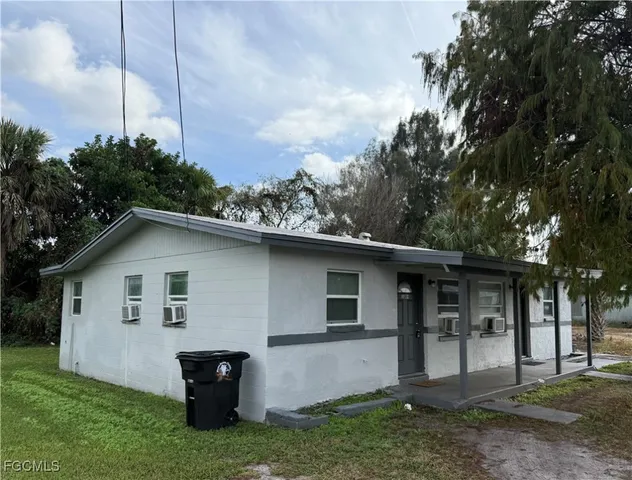 a front view of house with yard and trees around