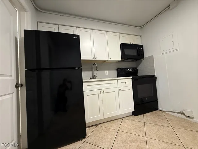 a kitchen with a refrigerator and a stove top oven