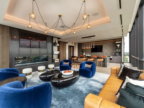 a living room with furniture kitchen view and a chandelier