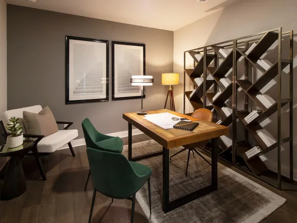 a view of a workspace room with furniture and window