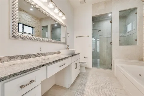a bathroom with a granite countertop sink mirror and bathtub