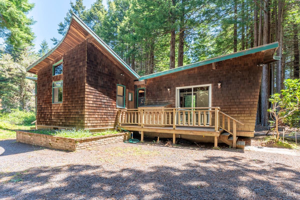 a view of a house with a yard and wooden fence