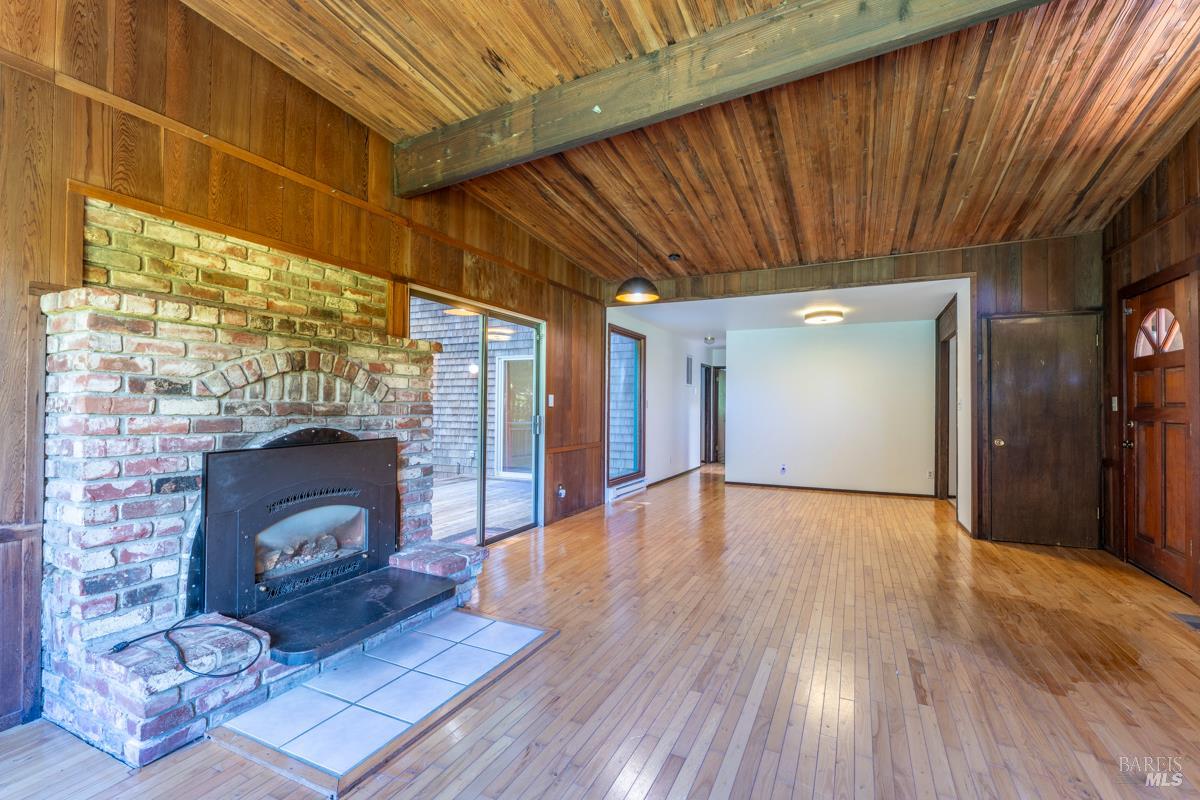 32371 Middle Ridge Road Albion, CA 95410 - Photo 7 of 35 a view of an empty room with wooden floor fireplace and a window