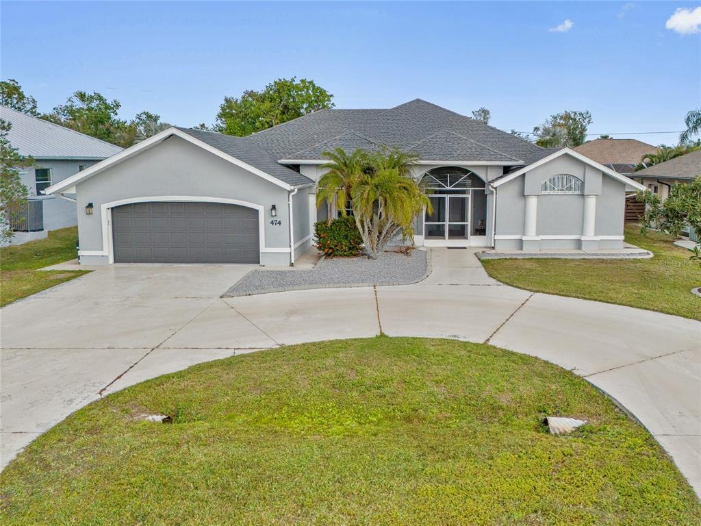 474 Orlando Boulevard Port Charlotte, FL 33954 - Photo 1 of 36 a front view of a house with a yard and garage