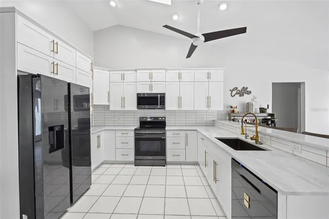 a kitchen with stainless steel appliances kitchen island granite countertop a table chairs and a refrigerator