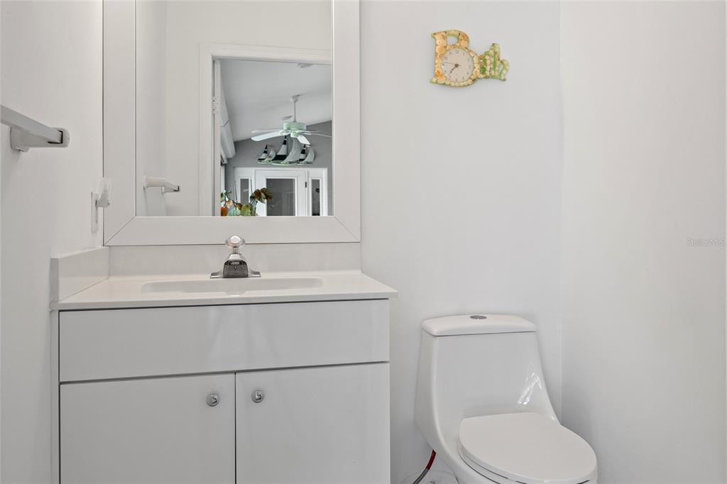 474 Orlando Boulevard Port Charlotte, FL 33954 - Photo 29 of 36 a bathroom with a toilet sink vanity and mirror