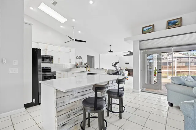 a kitchen with stainless steel appliances kitchen island granite countertop a table and chairs in it