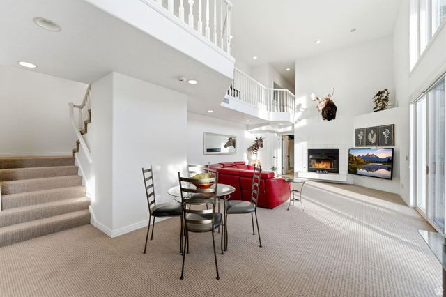 1878 East Ridge Point Drive Bountiful, UT 84010 - Photo 46 of 92 Dining area featuring light carpet, a tile fireplace, a high ceiling, and recessed lighting