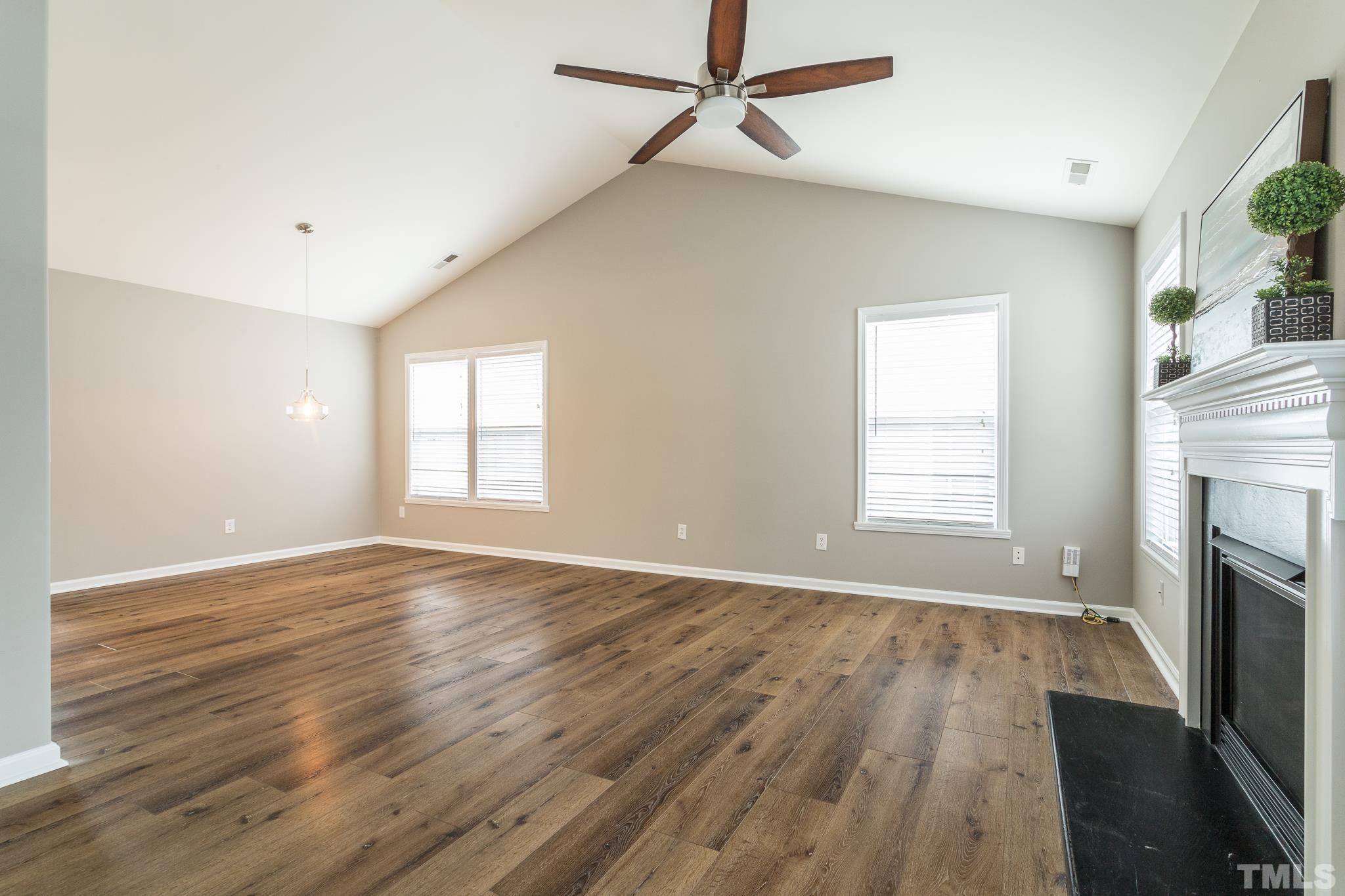 1307 Mallory Lane Durham, NC 27713 - Photo 11 of 29 an empty room with wooden floor fireplace and windows