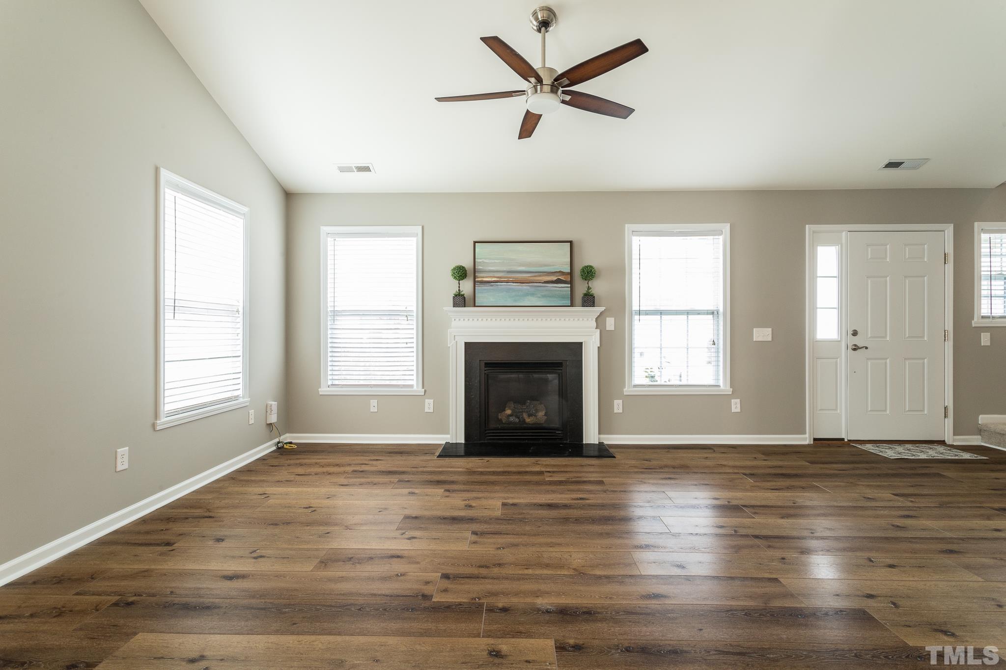 1307 Mallory Lane Durham, NC 27713 - Photo 12 of 29 an empty room with windows fireplace and wooden floor
