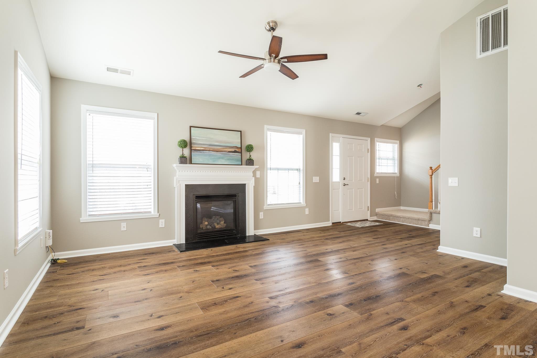 1307 Mallory Lane Durham, NC 27713 - Photo 13 of 29 an empty room with windows fireplace and wooden floor