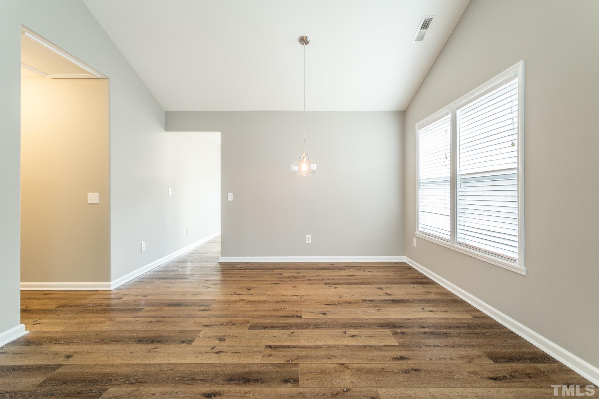 1307 Mallory Lane Durham, NC 27713 - Photo 15 of 29 a view of an empty room with wooden floor and a window