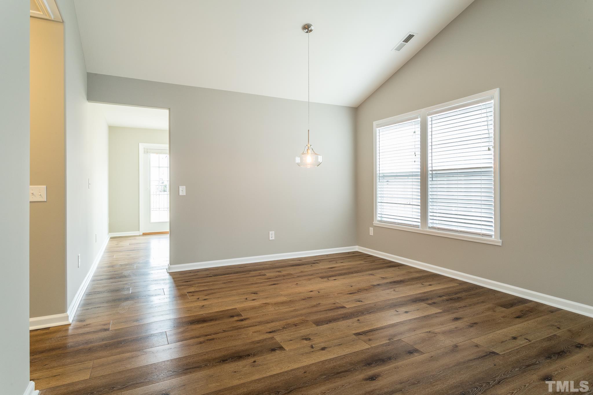 1307 Mallory Lane Durham, NC 27713 - Photo 16 of 29 a view of an empty room with wooden floor and a window