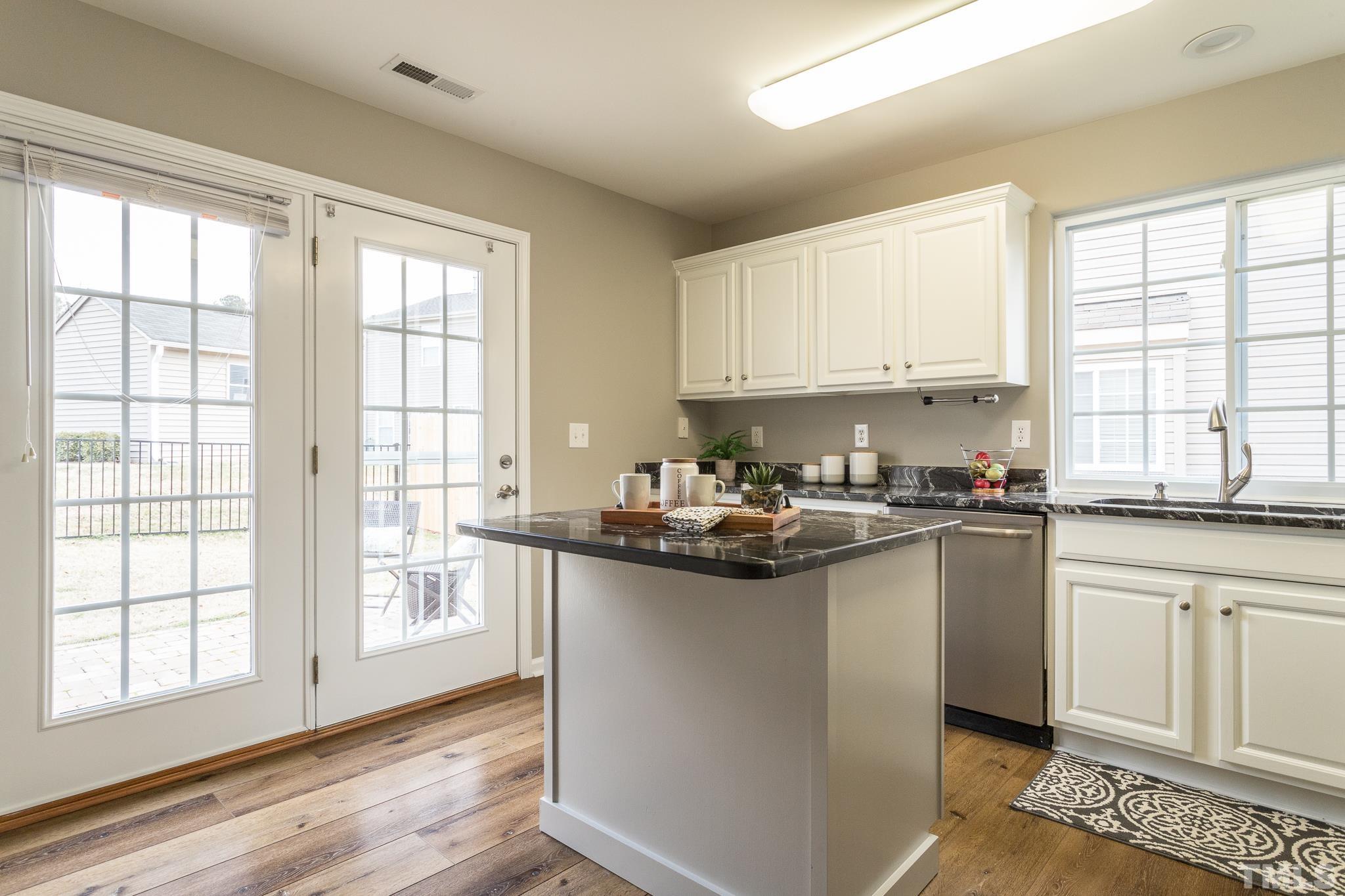 1307 Mallory Lane Durham, NC 27713 - Photo 18 of 29 a kitchen with stainless steel appliances granite countertop a sink a stove cabinets and a window