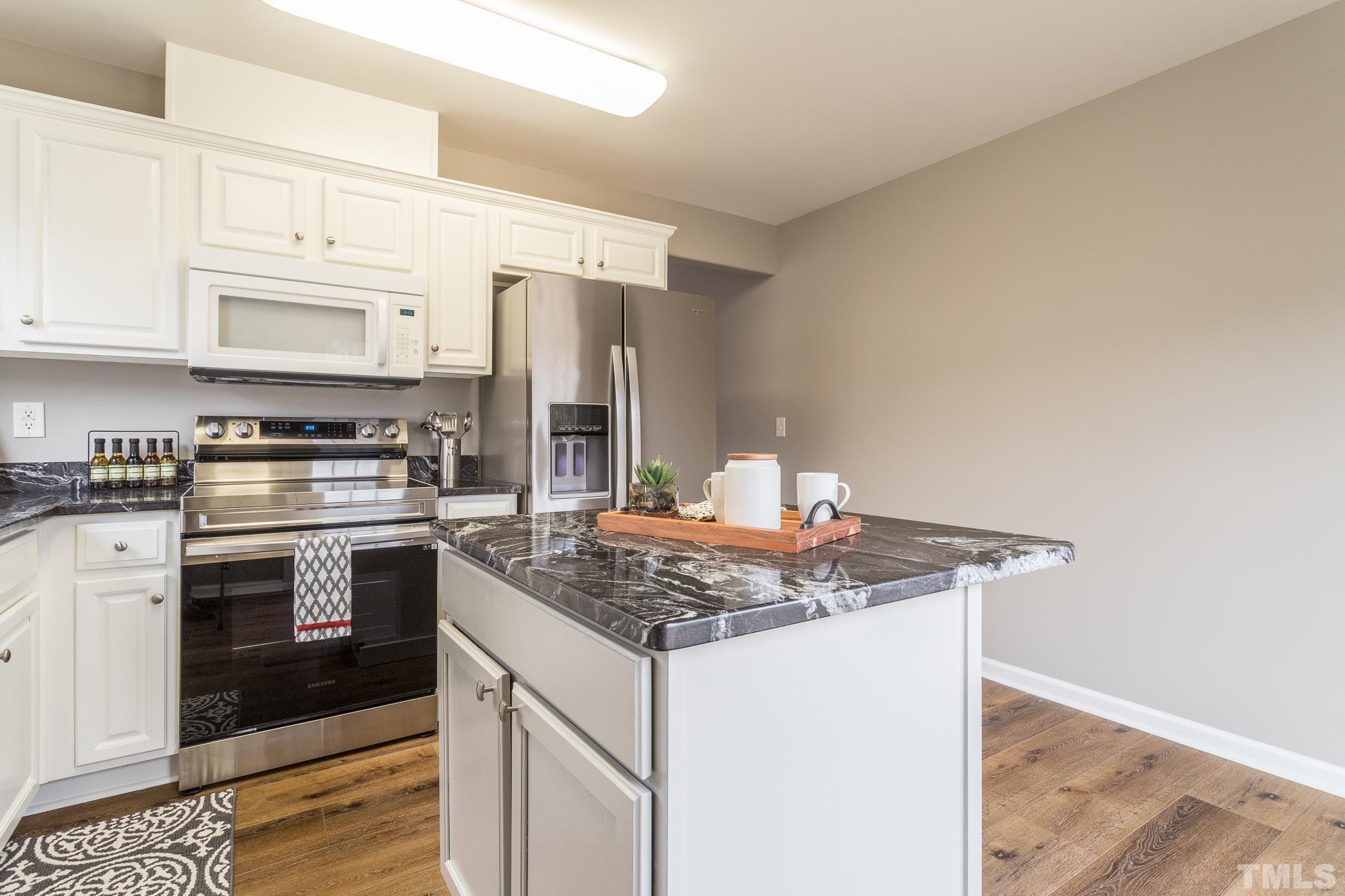 1307 Mallory Lane Durham, NC 27713 - Photo 20 of 29 a kitchen with stainless steel appliances granite countertop a stove a sink and a refrigerator