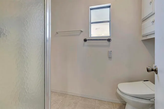 a white toilet sitting next to a shower