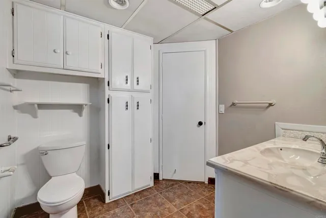a bathroom with a granite countertop sink a toilet and vanity