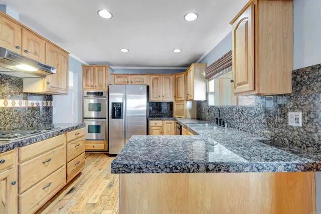 a kitchen with stainless steel appliances granite countertop a sink stove and refrigerator