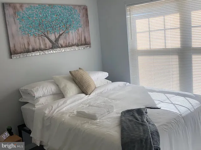 a large bed sitting in a bedroom next to a window