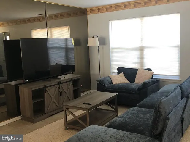 a living room with furniture a lamp and a window