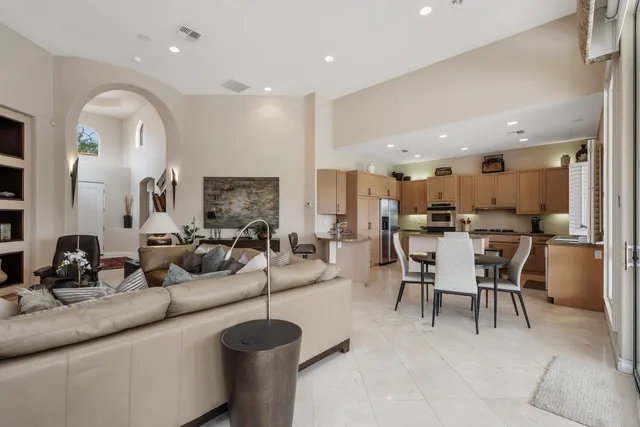 a living room with furniture a large window and potted plant