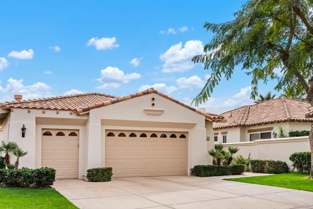 a front view of a house with a garden and garage