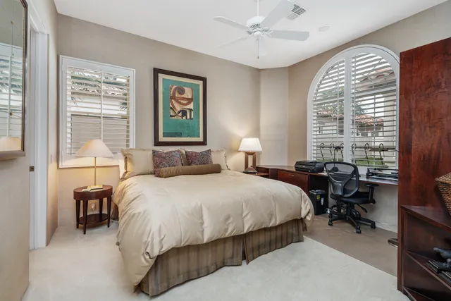 a bedroom with a bed and a large window