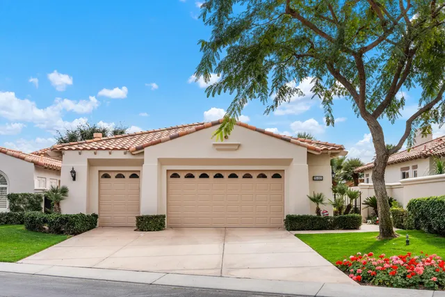 a front view of a house with a garden and garage