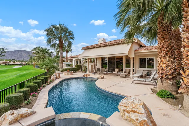 a view of a house with swimming pool and sitting area