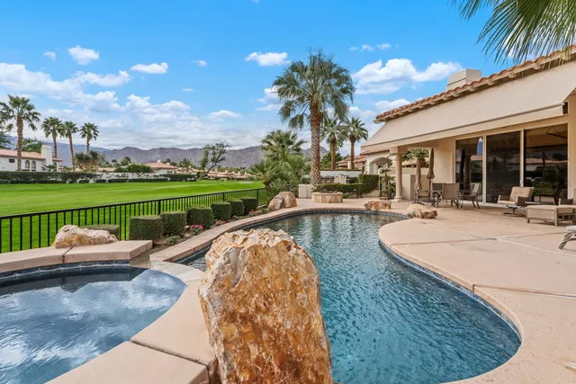 a swimming pool with outdoor seating and yard
