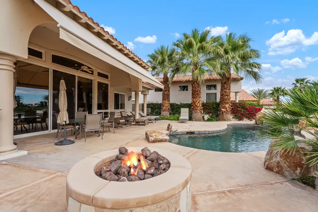 a view of a house with backyard and sitting area