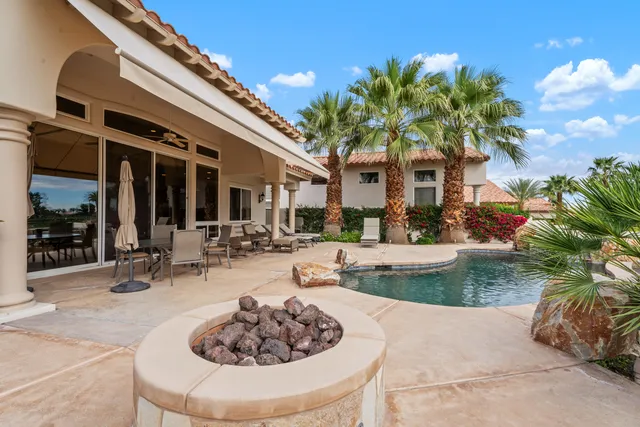 a view of a house with backyard and sitting area