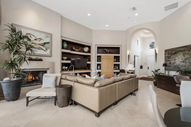 a living room with furniture a fireplace and a potted plant
