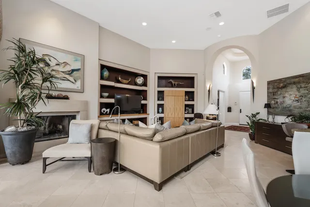 a living room with furniture a fireplace and a potted plant
