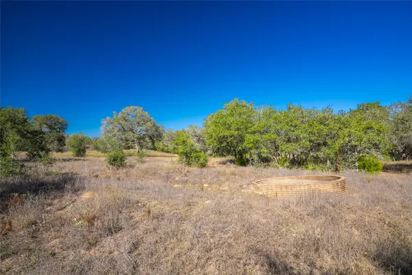 a view of a dirt road with trees in the background
