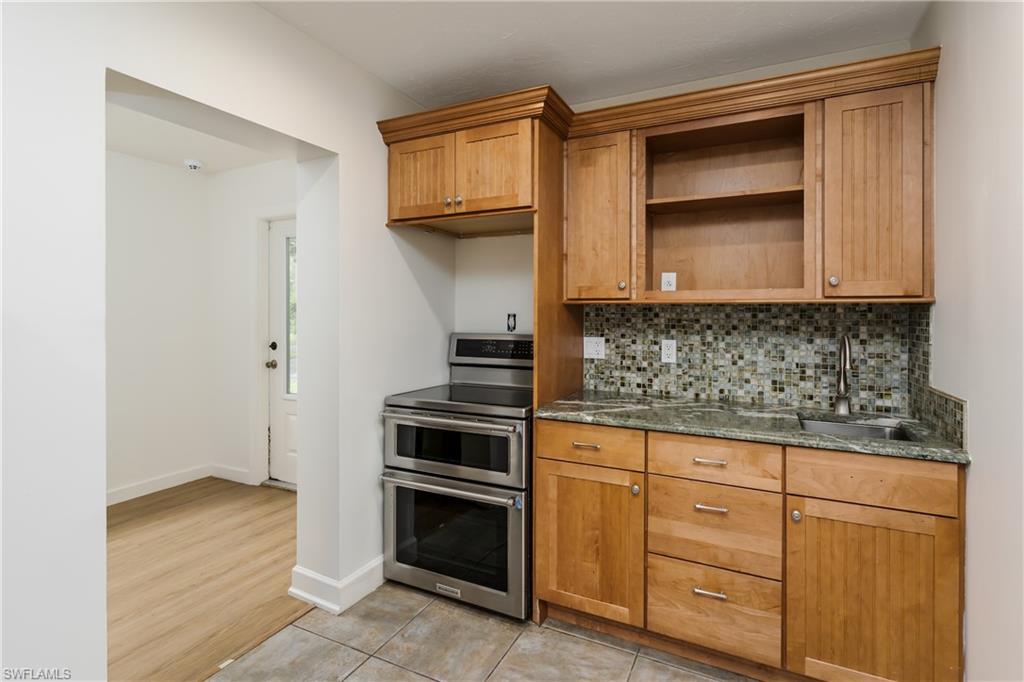 3301 31st Avenue Southwest Naples, FL 34117 - Photo 12 of 22 a kitchen with granite countertop a stove and a sink