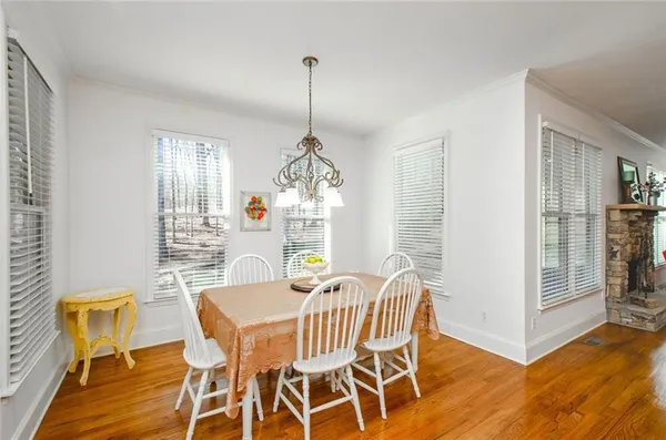a dining room with furniture a chandelier and wooden floor