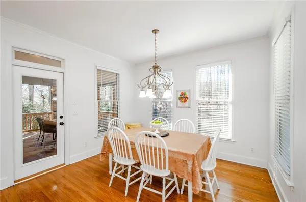 a kitchen with stainless steel appliances kitchen island granite countertop a table chairs and a refrigerator