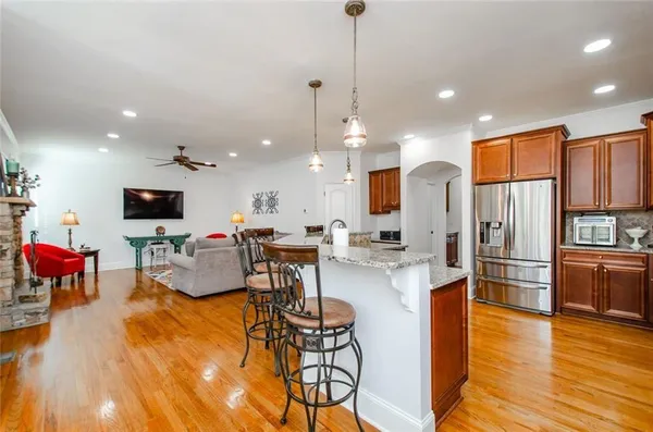 a kitchen with stainless steel appliances granite countertop a refrigerator a stove top oven and sink