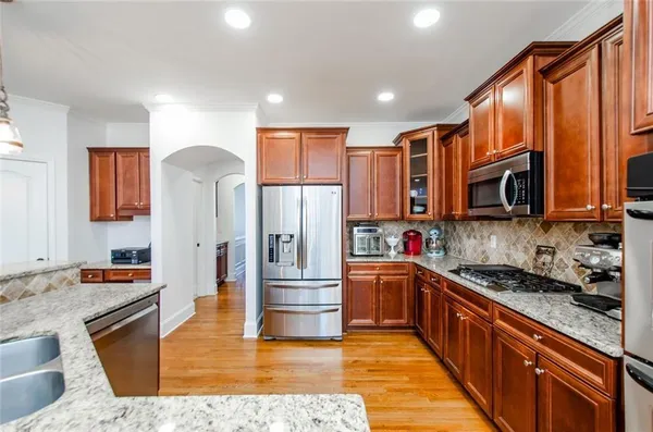 a large kitchen with stainless steel appliances granite countertop a stove a sink and a granite counter tops