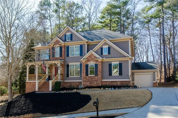a front view of a house with a yard and trees