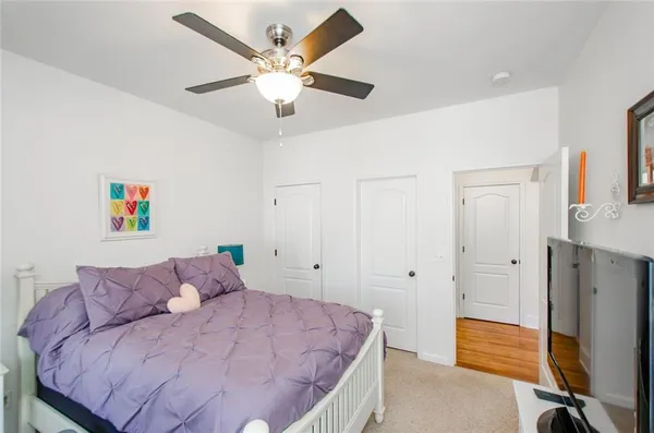 a bedroom with a bed and a flat tv screen on dresser