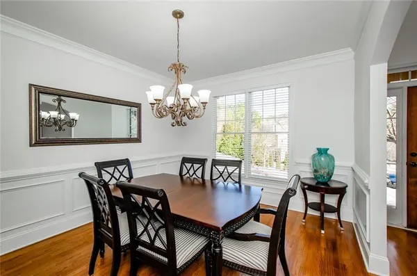 a view of a dining room with furniture a chandelier and wooden floor